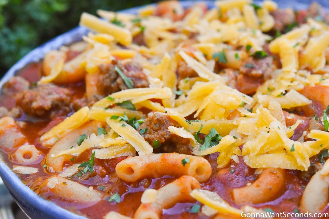 Instant pot goulash topped with shredded cheese in a blue bowl