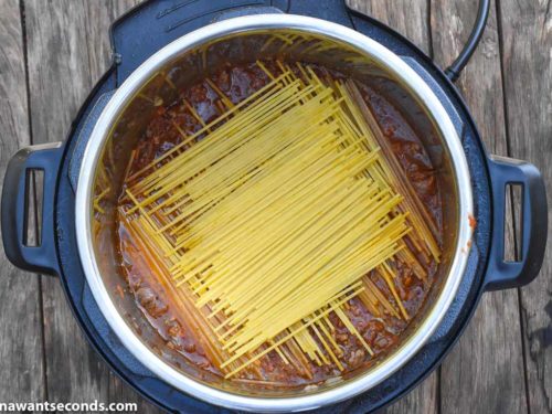 How To Make instant pot spaghetti with meat sauce, placing dry spaghetti on an instant pot with sauce