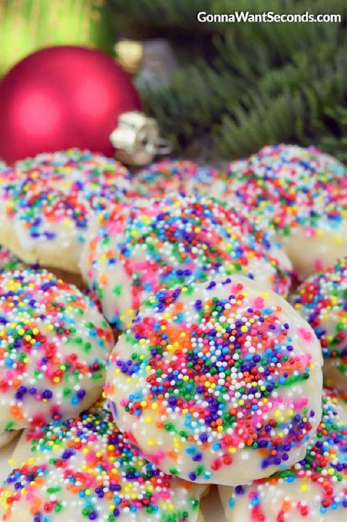 A pile of Italian Christmas Cookies, with Christmas decors at the back