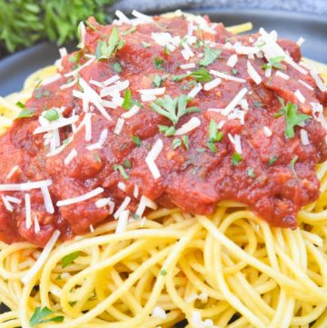 Spaghetti Meat Sauce poured over spaghetti, on a plate