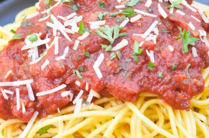 Spaghetti Meat Sauce poured over spaghetti, on a plate