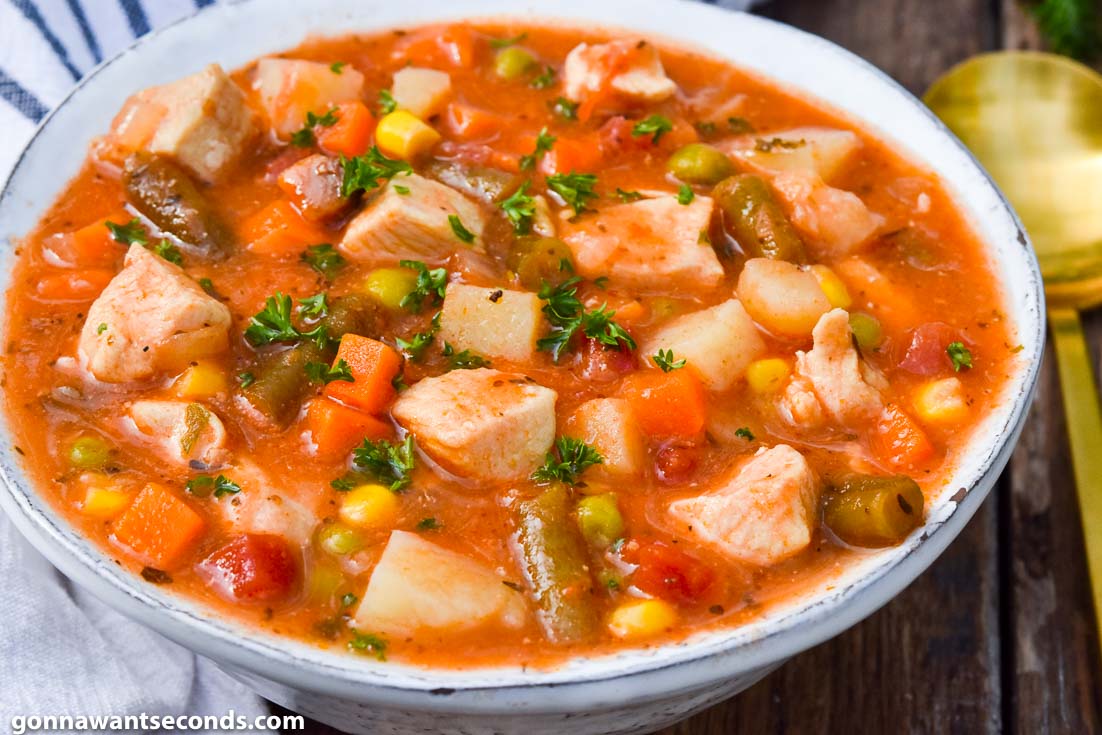 hearty chicken vegetable soup in a white bowl