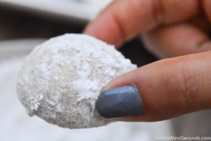 How to make Italian Wedding Cookies, rolling cookies on confectioner's sugar