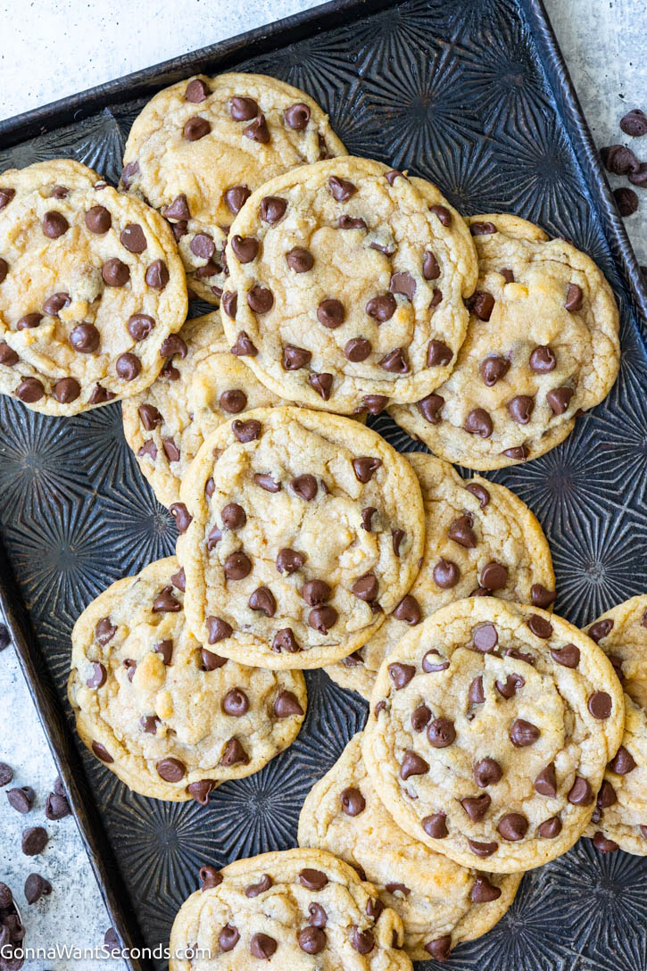 This easy chocolate chip cookies recipe checks all the boxes of a great cookie! They’re moist, chewy, chocolaty, & super easy to make! Prep in 15 minutes! #chocolatechipcookies #chipcookies easy chocolate chip cookies on a baking pan