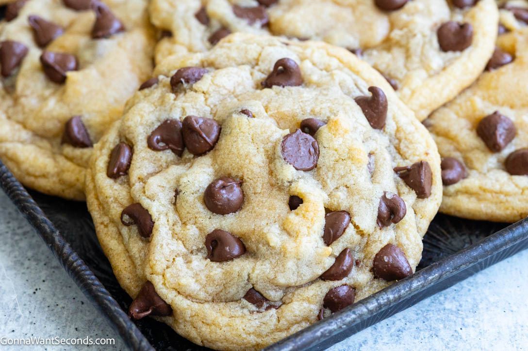 This easy chocolate chip cookies recipe checks all the boxes of a great cookie! They’re moist, chewy, chocolaty, & super easy to make! Prep in 15 minutes! #chocolatechipcookies #chipcookies easy chocolate chip cookies on a baking pan