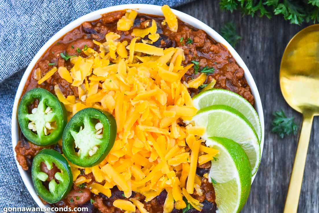Pioneer Woman Chili topped with cheese, jalapeno, and lime, on a bowl