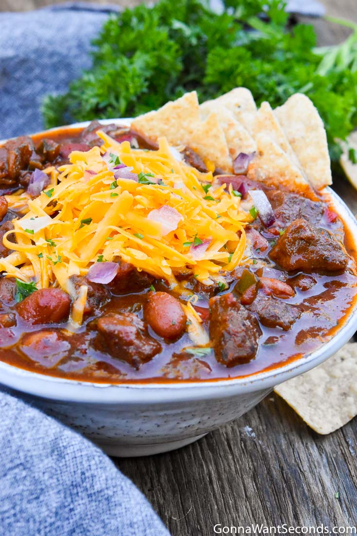 Steak Chili with toppings, on a white bowl