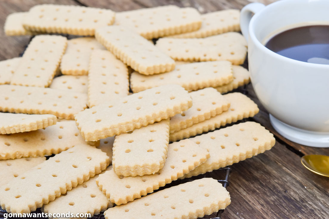 Brown Sugar Shortbread piled on top of each other with a cup of coffee on the side