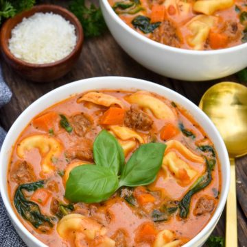 Creamy tortellini soup topped with fresh basil, in a bowl