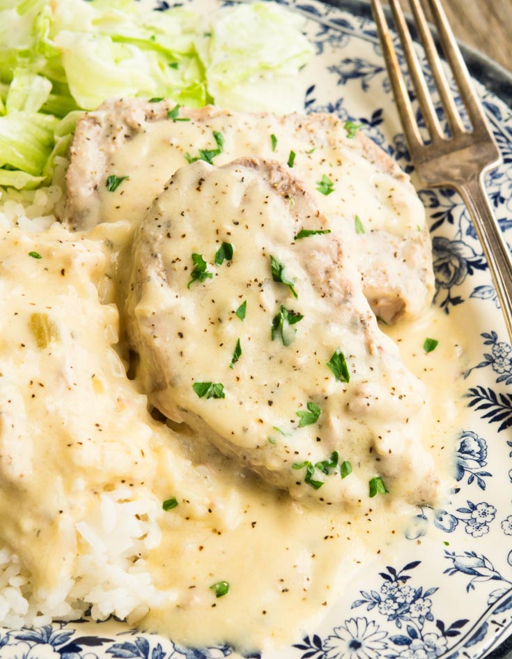 Crock Pot Ranch Pork Chops smothered in creamy gravy with rice and cabbage on the side