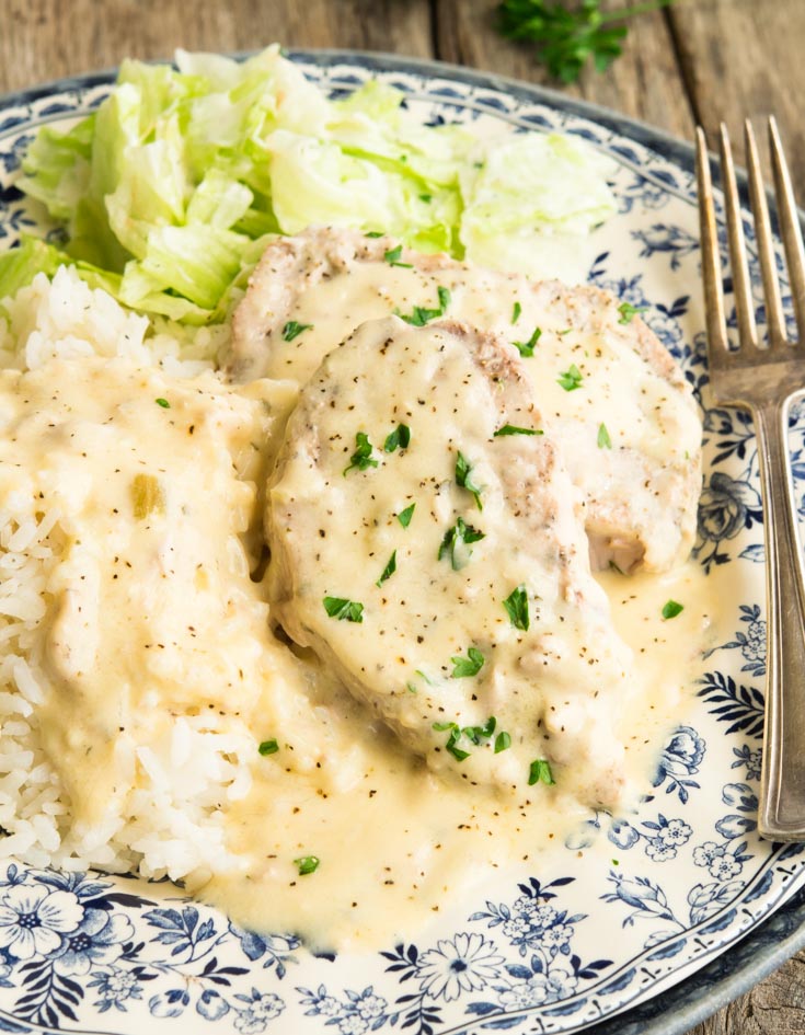 Crock Pot Ranch Pork Chops smothered in creamy gravy with rice and cabbage on the side