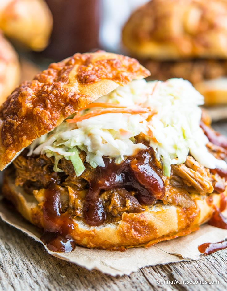 Crockpot Pulled Pork drizzled with bbq sauce, topped with coleslaw in a bun