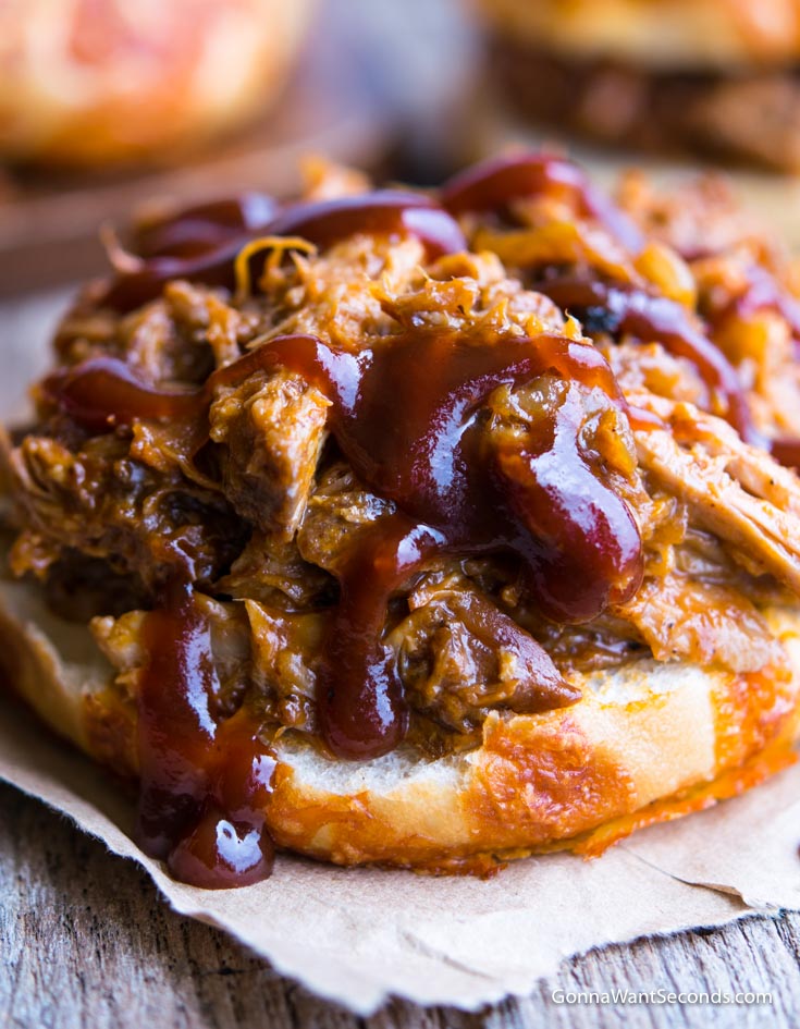 Crockpot Pulled Pork drizzled with bbq sauce in a bun