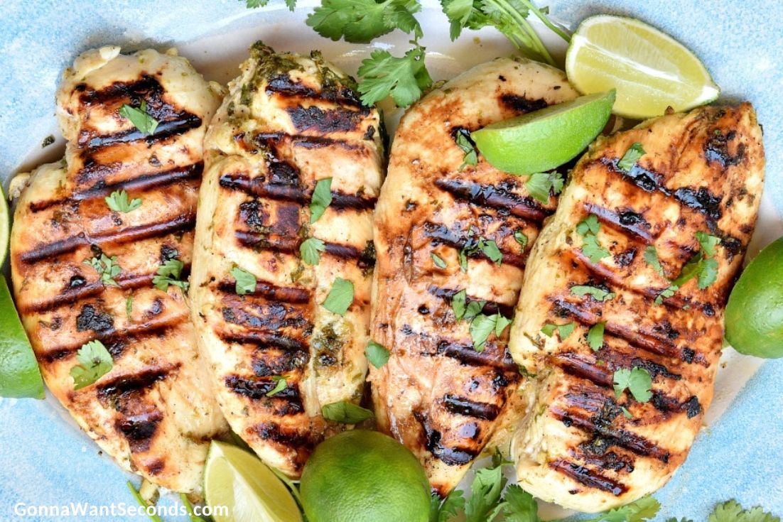 cilantro lime chicken breast garnished with lime wedges and cilantro on a plate