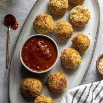 Air fryer arancini recipe on a platter with dip