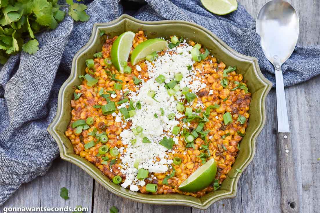 Mexican street corn casserole topped with cheese and lime