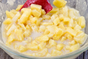 Step 3 how to make Pineapple Ritz Casserole, Toss the pineapple chunks in the flour mixture.