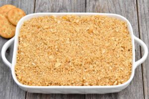 Step 6 how to make Pineapple Ritz Casserole, Sprinkle the crushed cracker and butter mixture over the cheese. Bake.