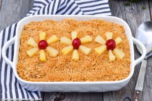 Baked Pineapple Casserole topped with pineapple tidbits and cherries