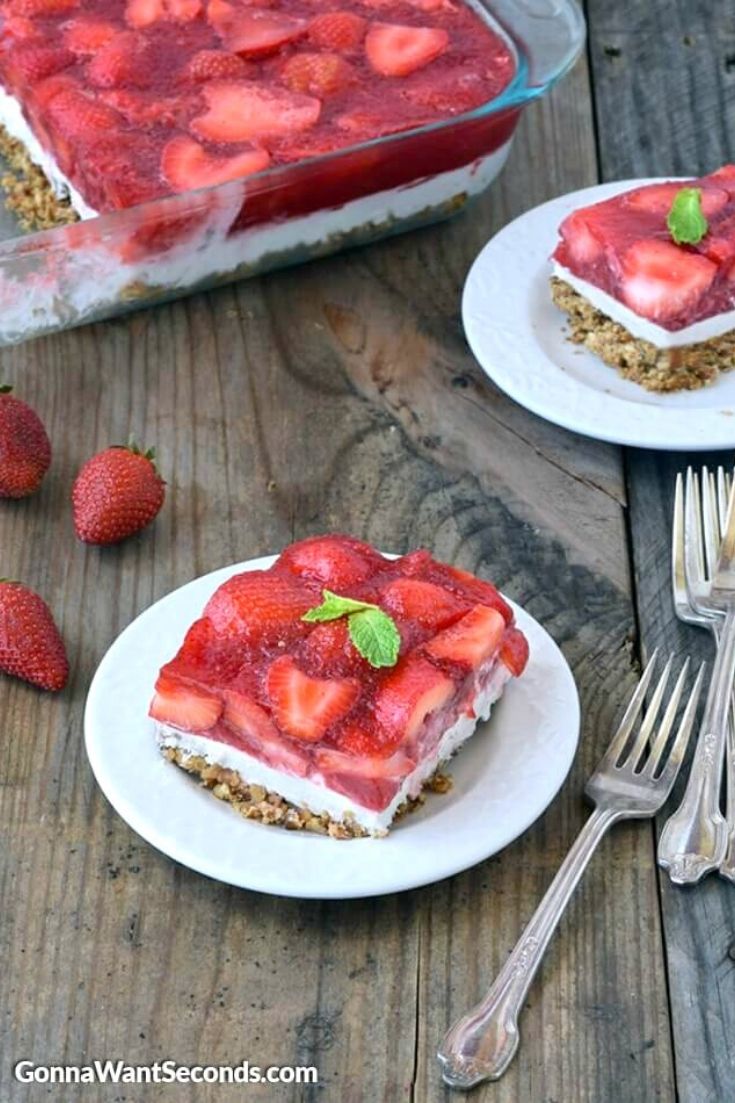 strawberry pretzel salad on a plate with baking dish at the back