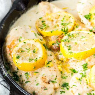 Creamy Lemon Chicken with sauce in a cast iron skillet