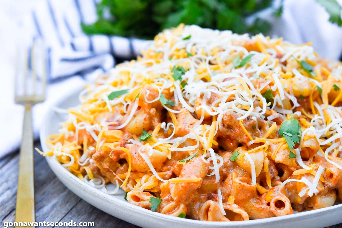 taco pasta topped with shredded cheese on a plate