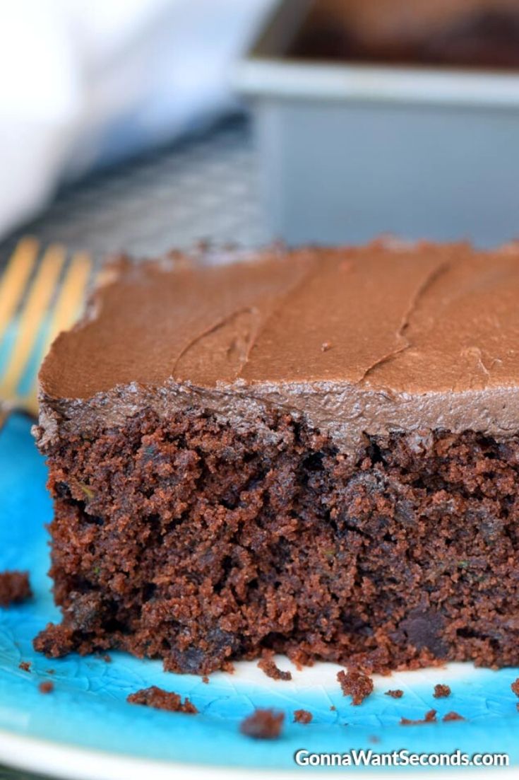 A slice of chocolate zucchini cake on a blue plate