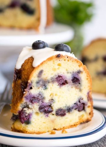A slice of Blueberry Coffee Cake topped with fresh blueberries