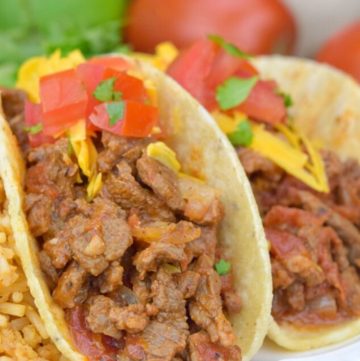 Carne Picada in taco shells, topped with cheese and tomatoes