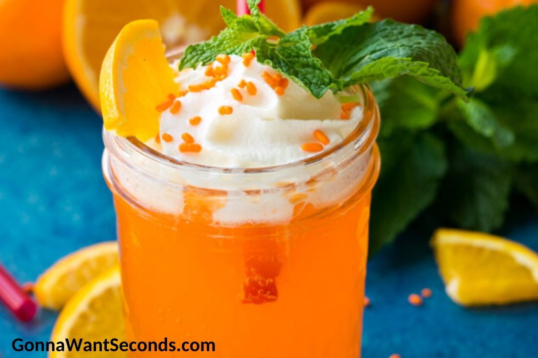 orange creamsicle drink topped with whipped cream and sprinkles