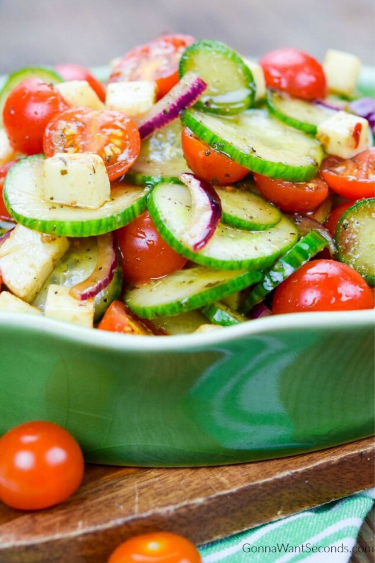 cucumber tomato salad in a shallow green bowl