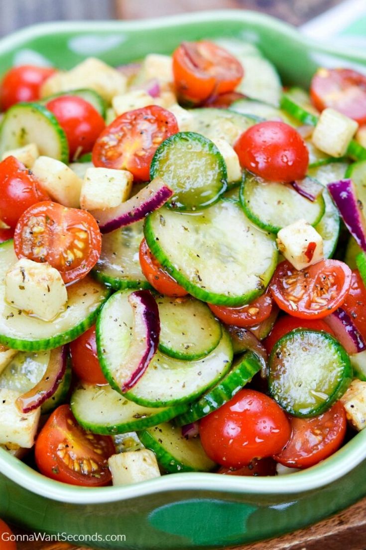 cucumber tomato salad in a shallow green bowl
