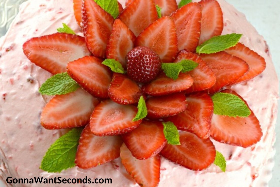 strawberry layer cake topped with fresh strawberries