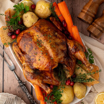 Whole Million dollar chicken with vegetables on a serving platter