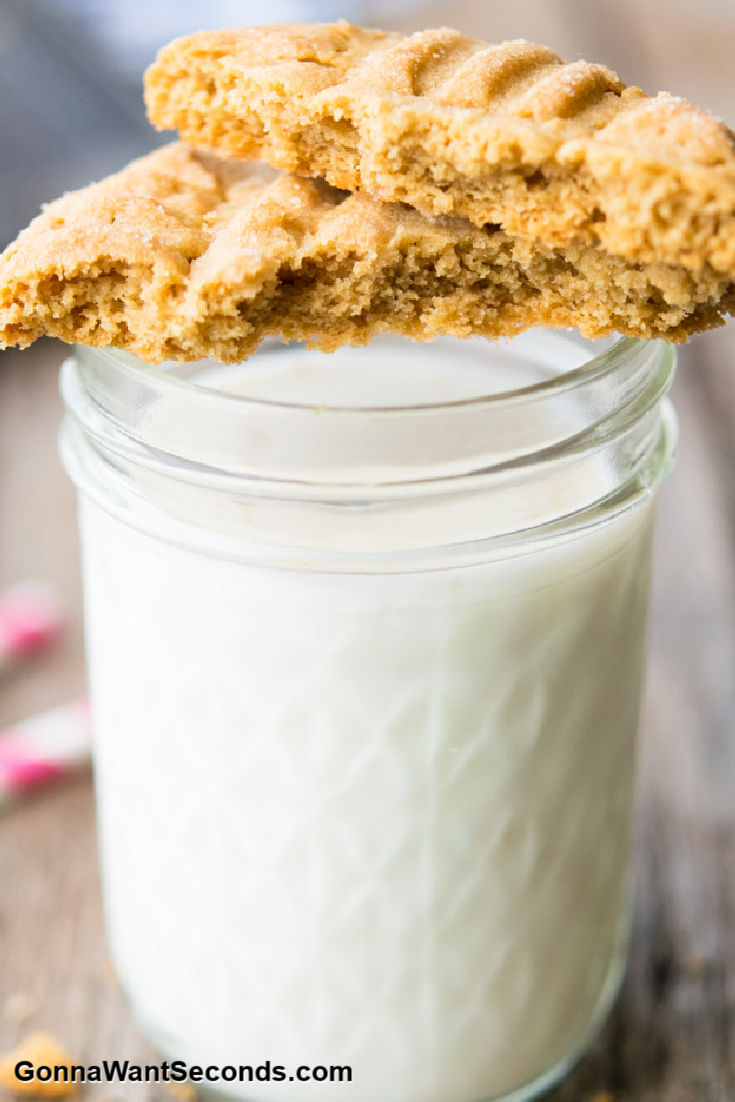 peanut butter cookie on top of a glass of milk