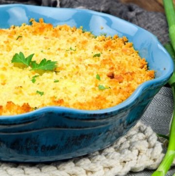 Scalloped corn in a blue baking dish, close up