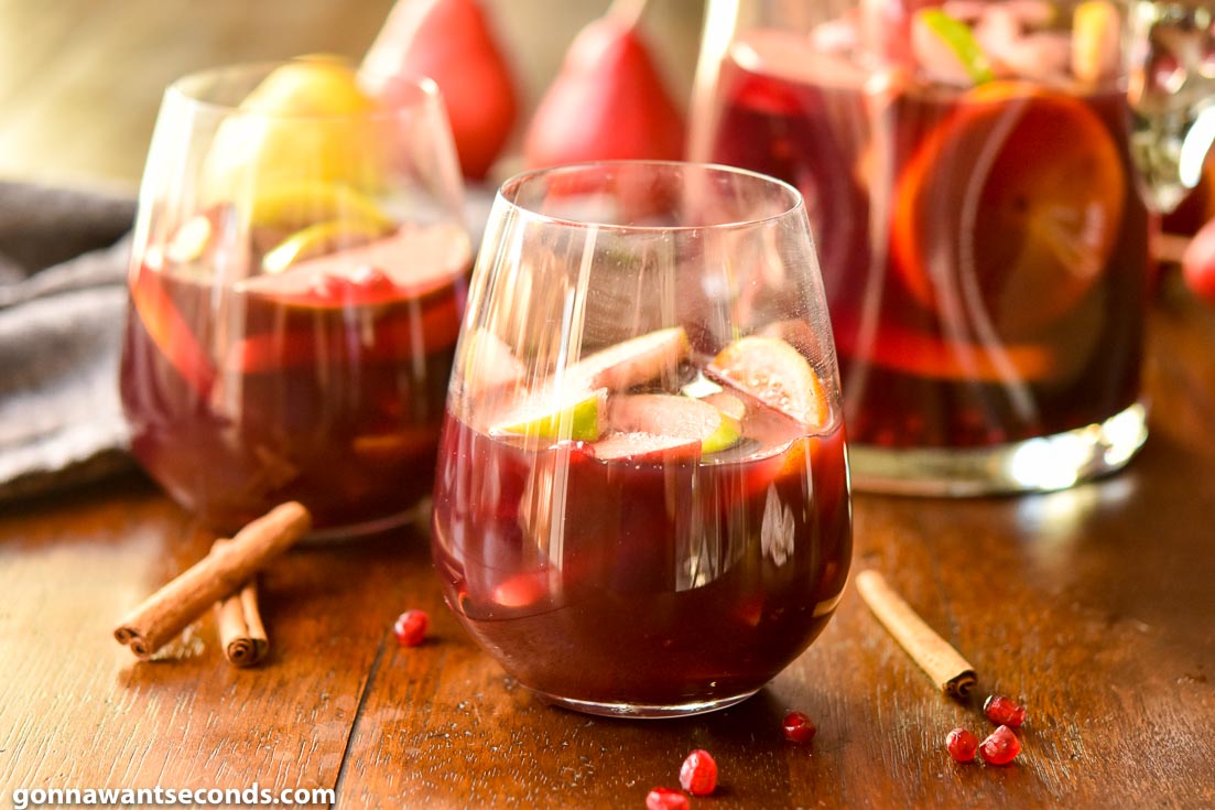 two glasses and a pitcher of red wine christmas sangria