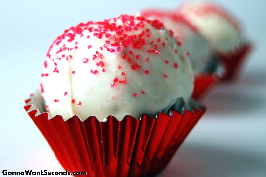 Red Velvet Cake Balls with red colored sugar sprinkled on top, in a red cupcake liner