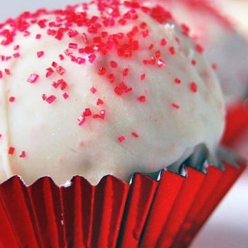 Red Velvet Cake Balls with red colored sugar sprinkled on top, in a red cupcake liner