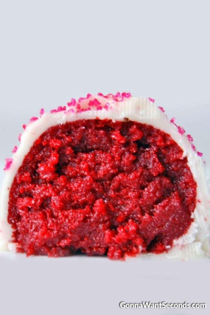 Red Velvet Cake Balls with red colored sugar sprinkled on top, cut in half