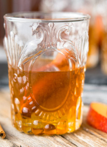A glass of Apple Pie Moonshine with cinnamon stick