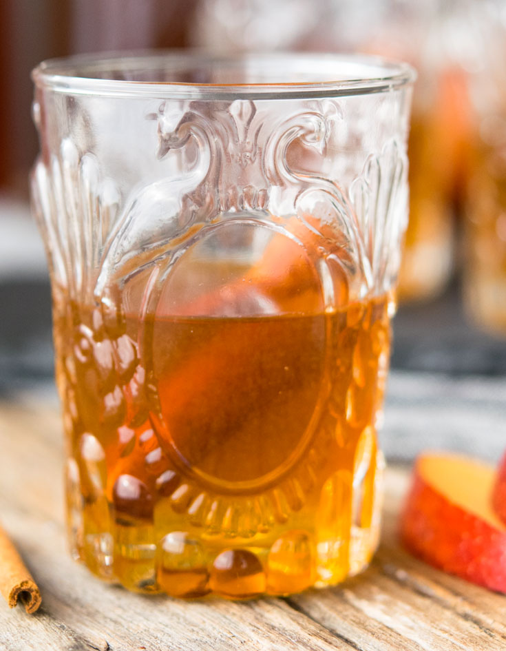 A glass of Apple Pie Moonshine with cinnamon stick 