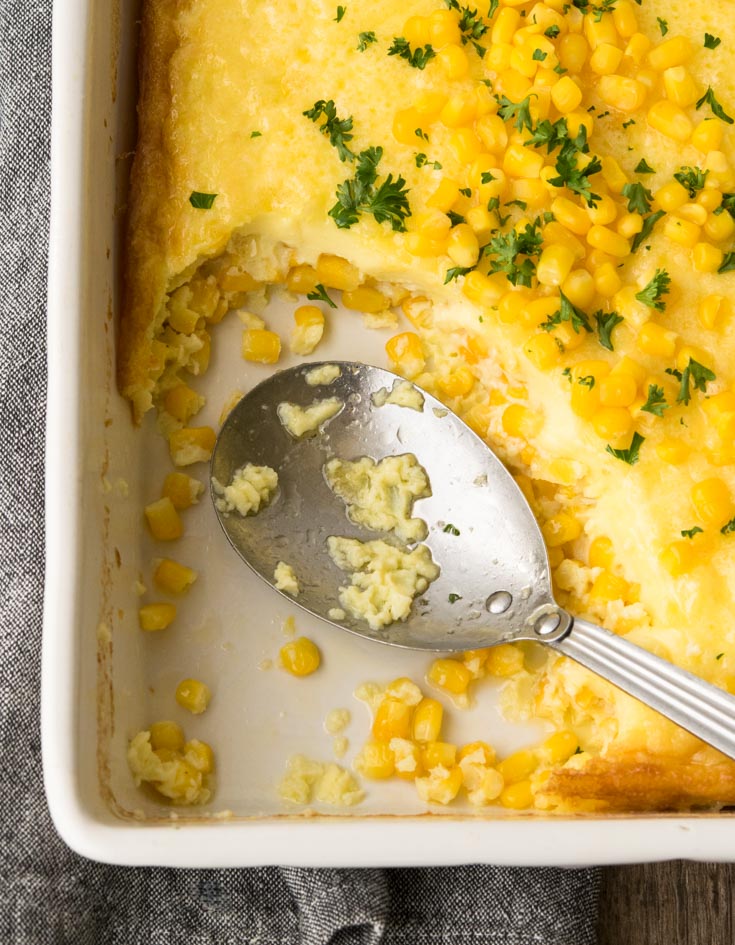 One portion of Corn Pudding scooped out of a rectangular casserole dish