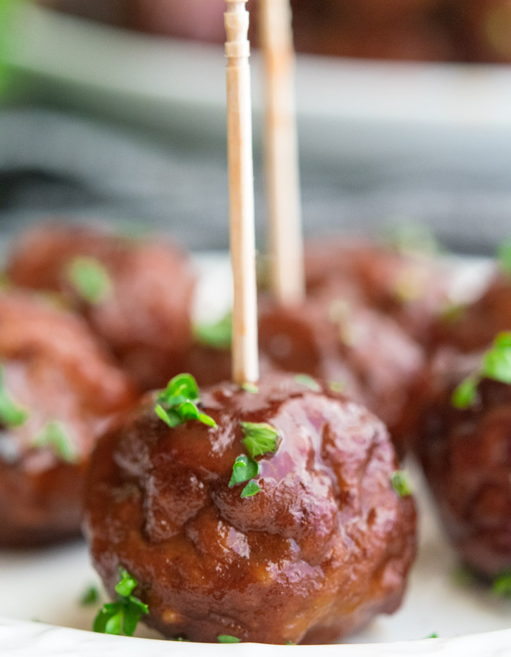 Grape Jelly Meatballs with toothpicks, sprinkled with chopped parsley