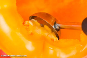 How to make Italian Stuffed Peppers, scooping the bell pepper seeds