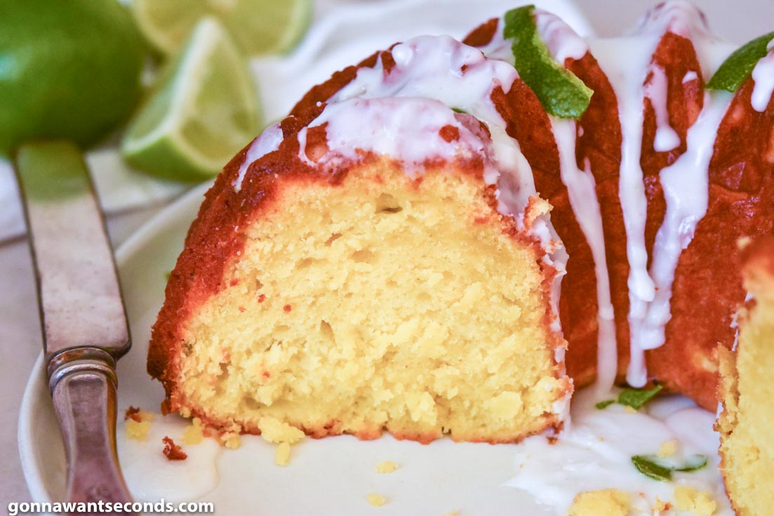 A slice of Margarita Cake with glaze and lime peel on top