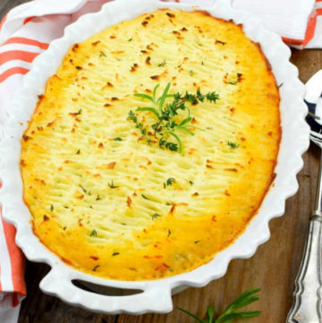 Zesty, flavorful ground meat under a mountain of buttery mashed potatoes makes the perfect comfort food in this Alton Brown Shepherd's Pie recipe! #AltonBrown #ShepherdsPie #MeatPie #CottagePie #Pies