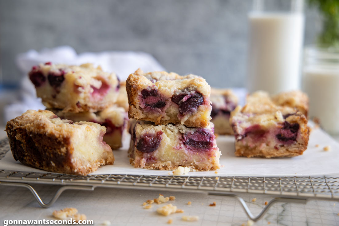 Cherry Custard Pie Bars stack on top of each other on a cooling rack