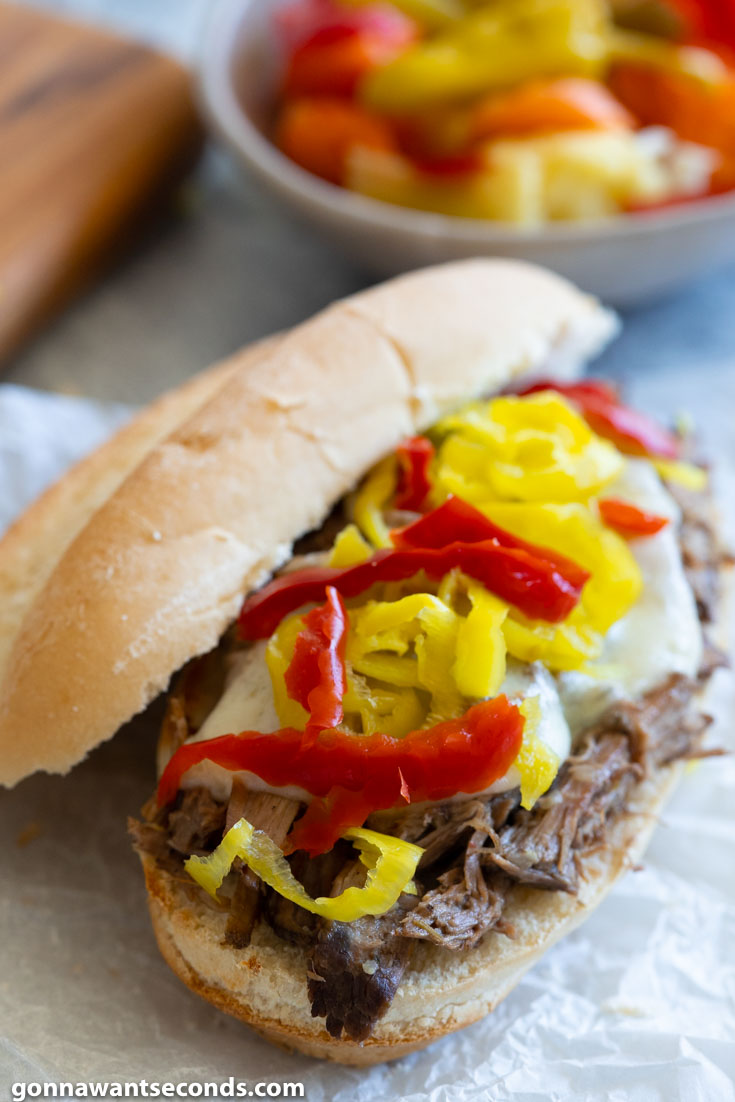 crockpot Italian beef sandwiches, topped with pepperoncini and extra Giardiniera, close up
