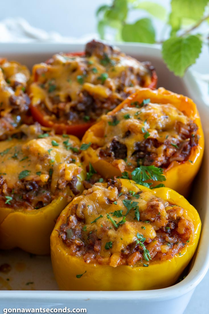 stuffed peppers topped with melted cheese, in a baking dish